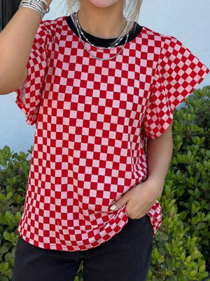Red and white checkered print shirt with ruffle sleeves and a black neckline.