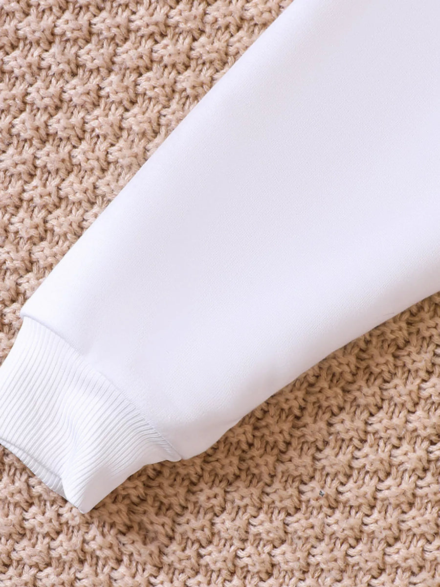 White baby sweatshirt sleeve with ribbed cuff on textured background