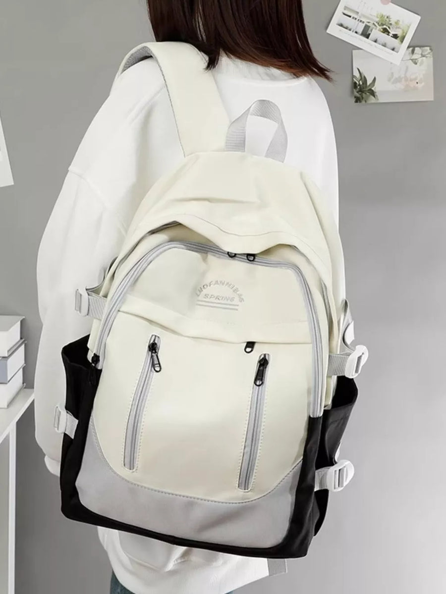 Chic color block nylon backpack in cream, gray, and black with adjustable straps and multiple zippered pockets.