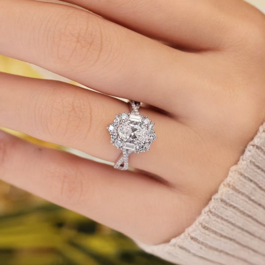 Sterling silver moissanite halo ring with oval center stone and baguette accents.