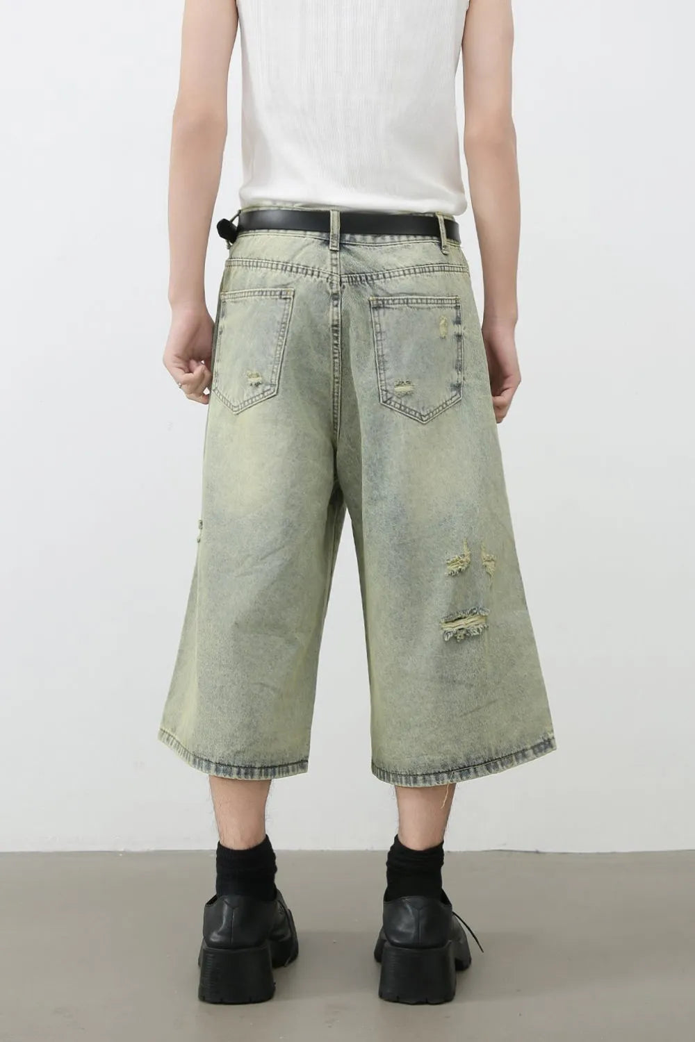 Distressed culotte denim shorts in medium wash with ripped details and a wide leg.