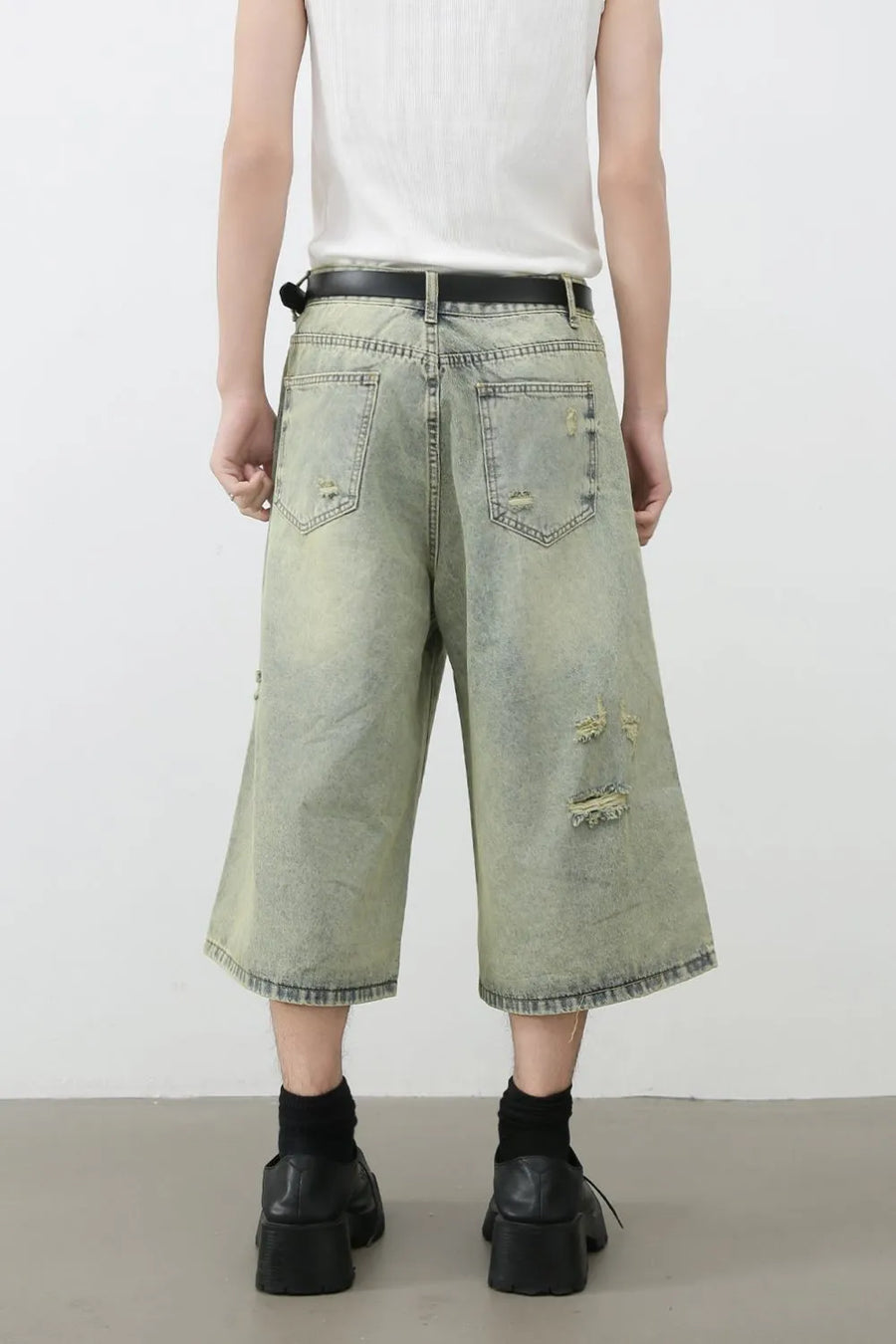 Distressed culotte denim shorts in medium wash with ripped details and a wide leg.