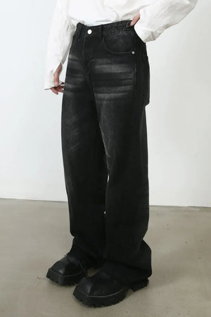 Dark wash barrel leg jeans with whiskering detail, styled with a white shirt and chunky black boots.