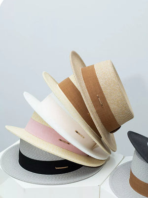 Straw boater hats in beige, blush pink, gray, and black with ribbon details.