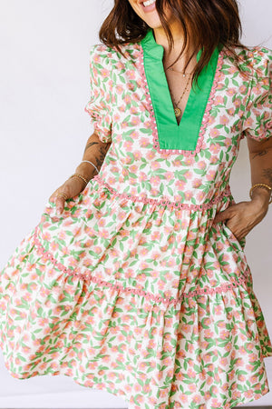 Tiered mini dress with floral print, green V-neck, and pink trim.