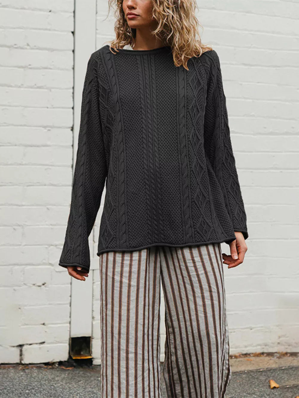 Black pullover sweater featuring cable-knit and cable knit