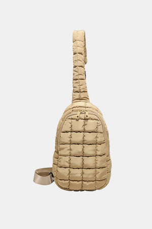 Padded sling bag in Camel with top handle and adjustable strap.