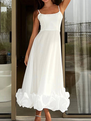 White midi dress with spaghetti straps and a ruffled hem.