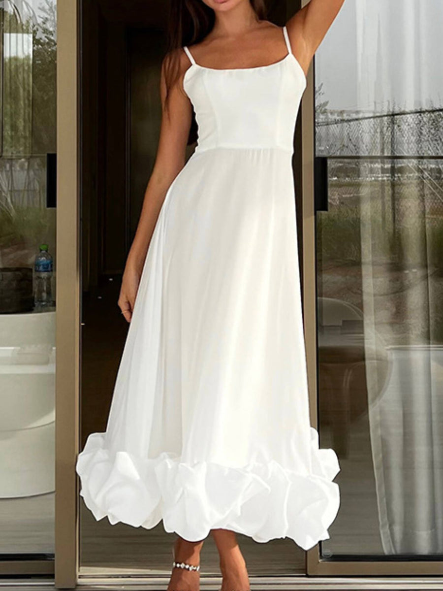 White midi dress with spaghetti straps and a ruffled hem.