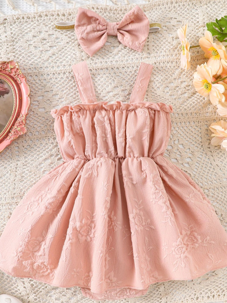 Pink floral embossed baby one-piece dress with ruffled neckline and matching bow headband.