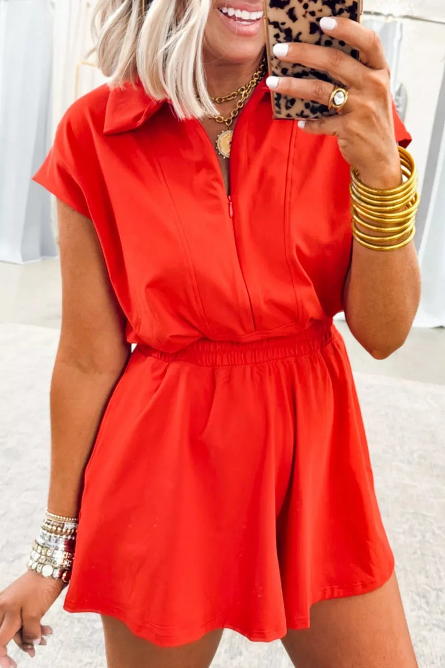 Red cotton romper with polo collar, short sleeves, and elastic waist.