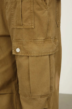 Khaki cargo pants with large pleated side pockets and button closures.