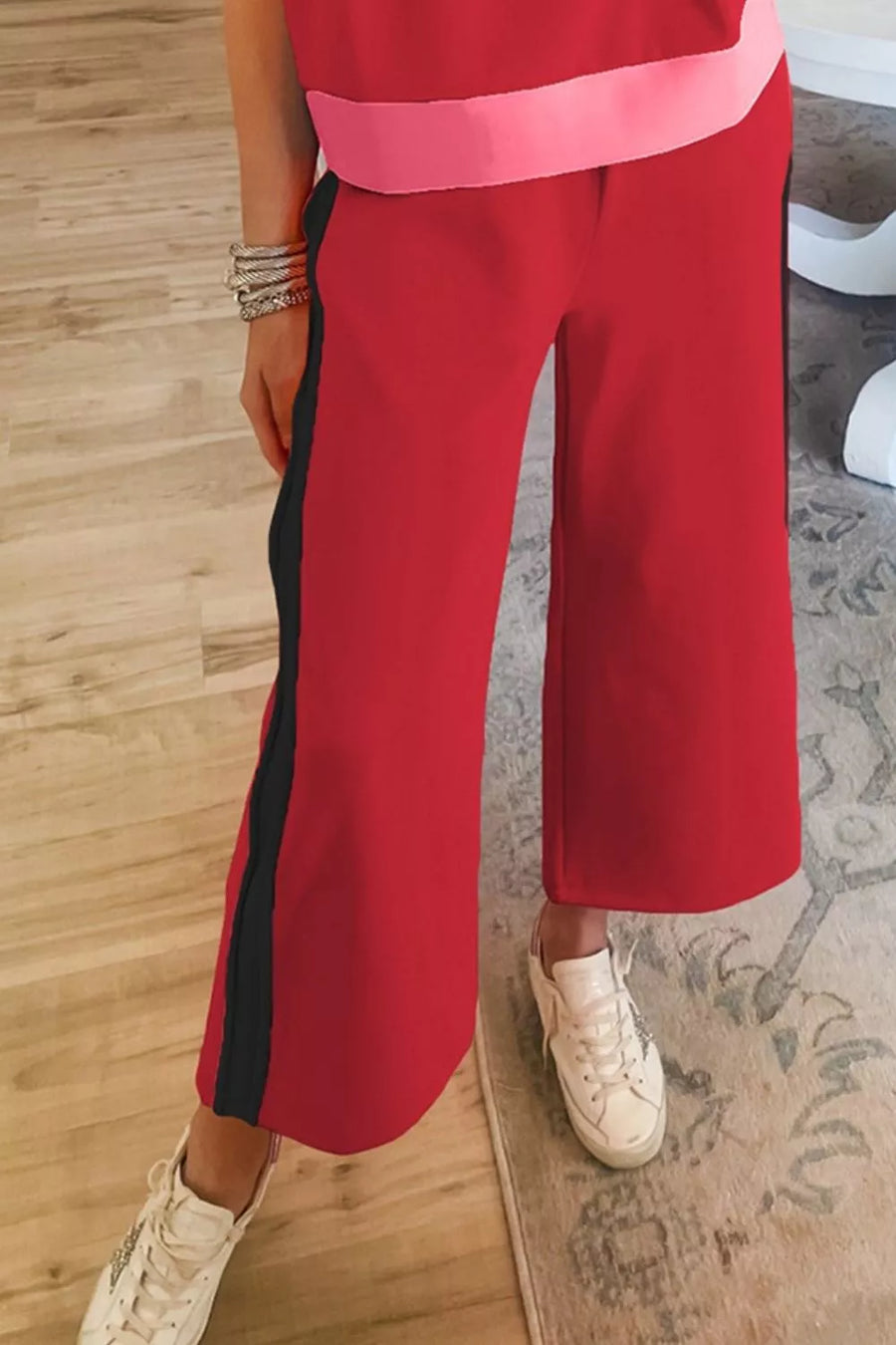 Red wide leg pants with black side stripe and pink waistband detail.
