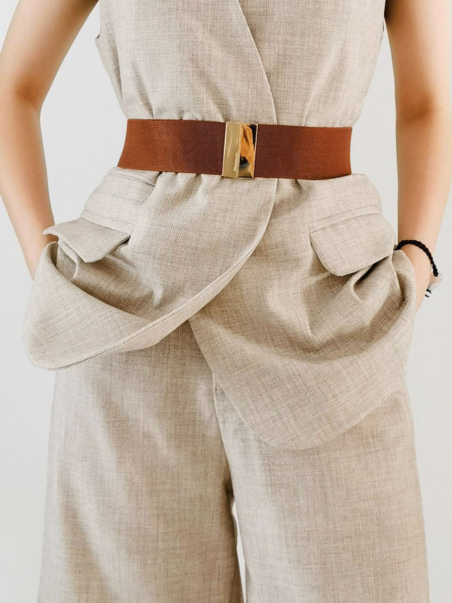 Wide elastic belt in Chestnut with gold clasp, cinching a linen blend outfit.