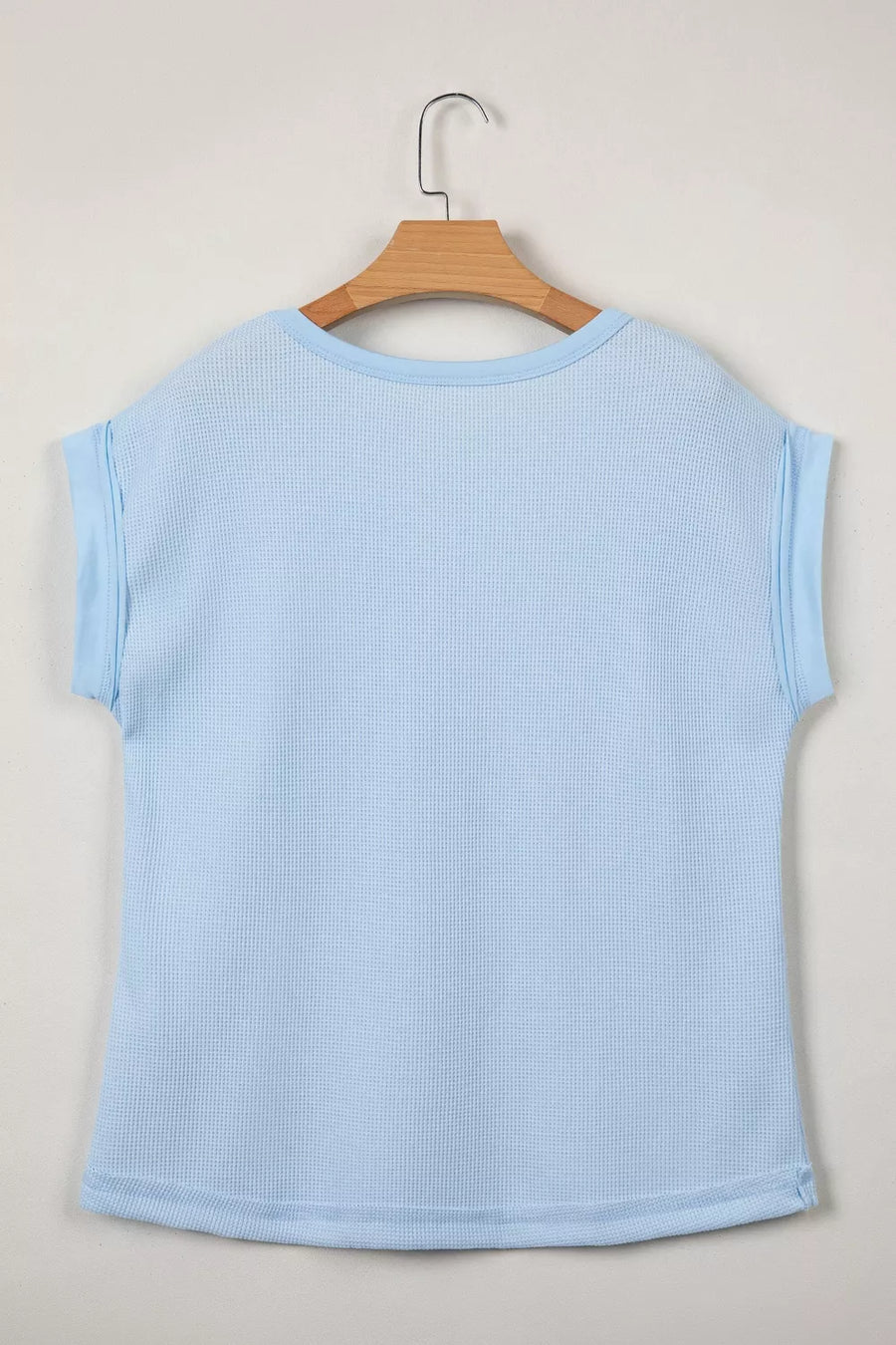 Light blue waffle knit t-shirt with cuffed sleeves and curved hem.