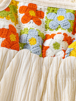 Crochet baby jumpsuit with colorful floral squares and cream ruffled trim