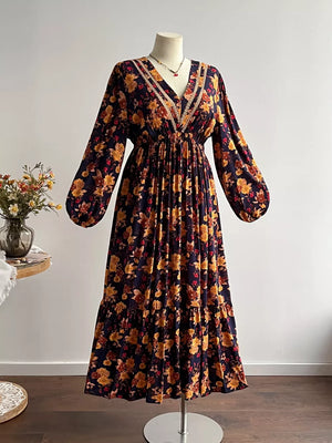 Floral V-neck maxi dress with long sleeves, tiered skirt, and lace trim.