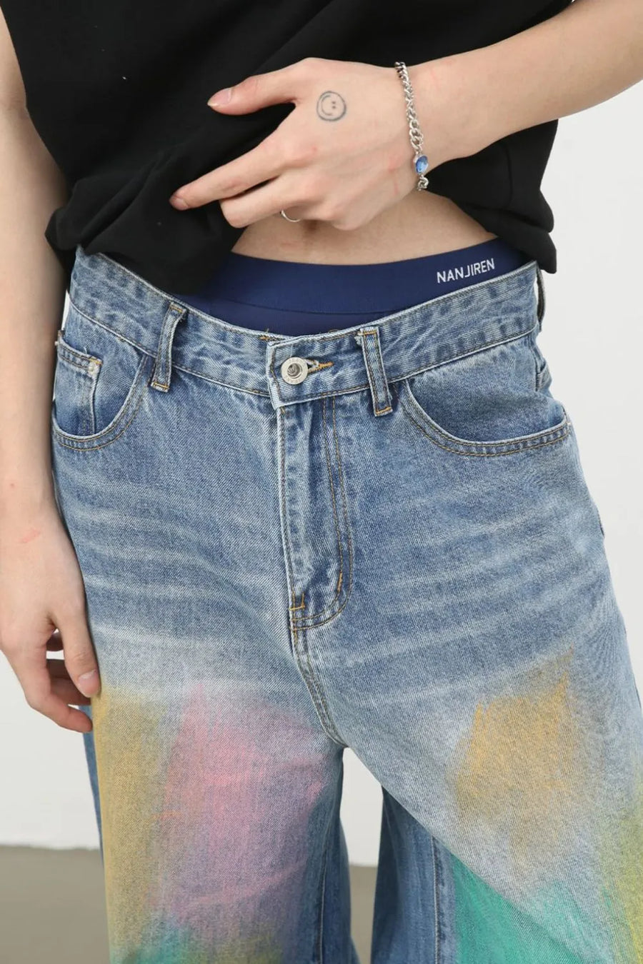 Graffiti wash wide leg denim trousers in medium blue with colorful spray paint details.