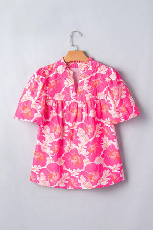 Vibrant floral print polyester blouse with ruffled neckline and bubble sleeves.