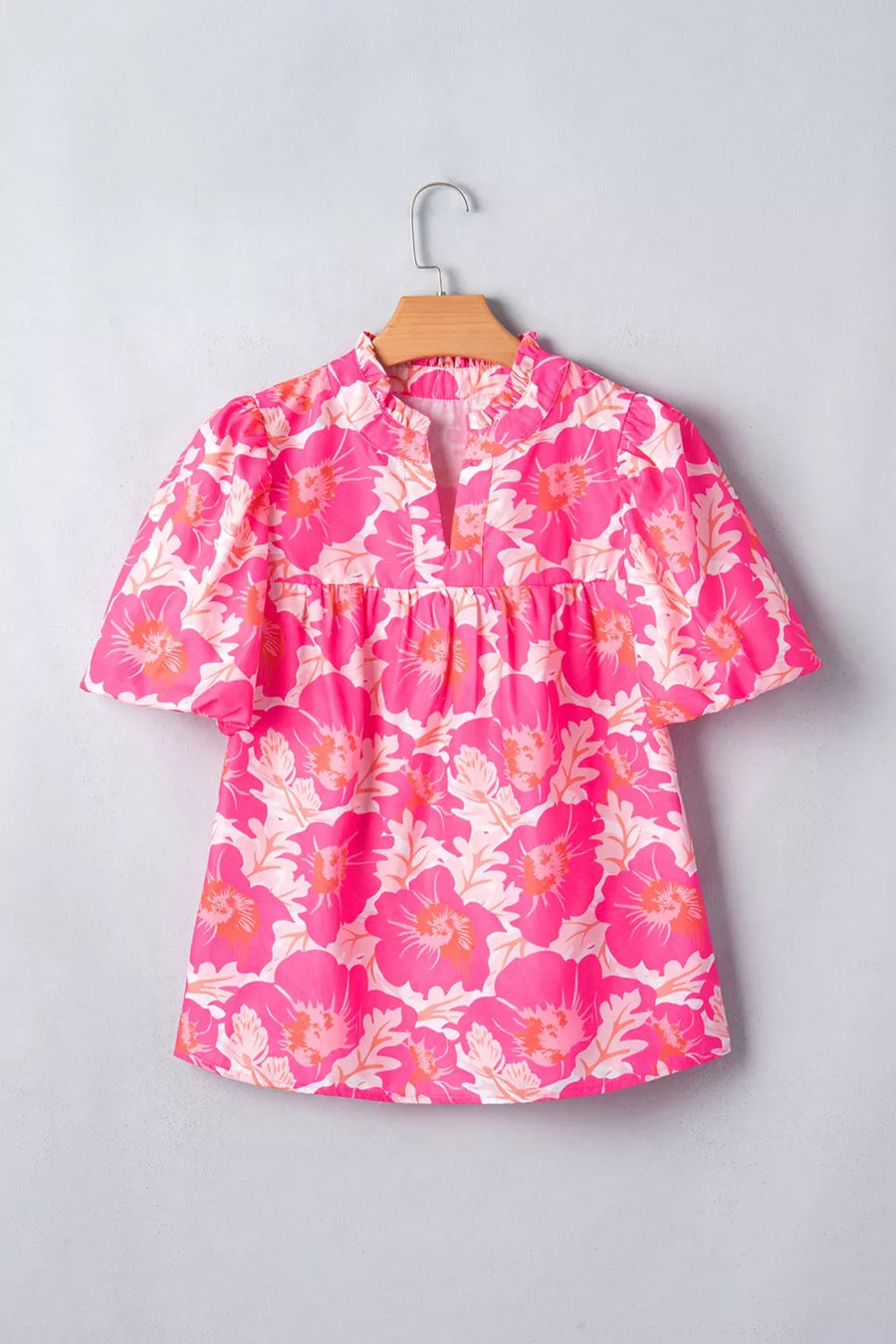 Vibrant floral print polyester blouse with ruffled neckline and bubble sleeves.