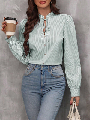 Green striped blouse with puff sleeves and neck tie detail.