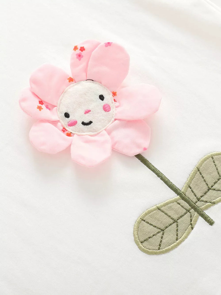 Toddler cotton set with a pink floral applique featuring a smiling face and embroidered leaves.