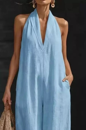 Light blue halter neck jumpsuit with pockets and a deep V-neck.