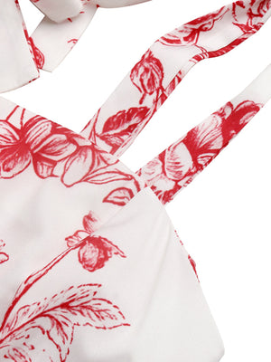 White maxi dress with red floral print and tie straps.