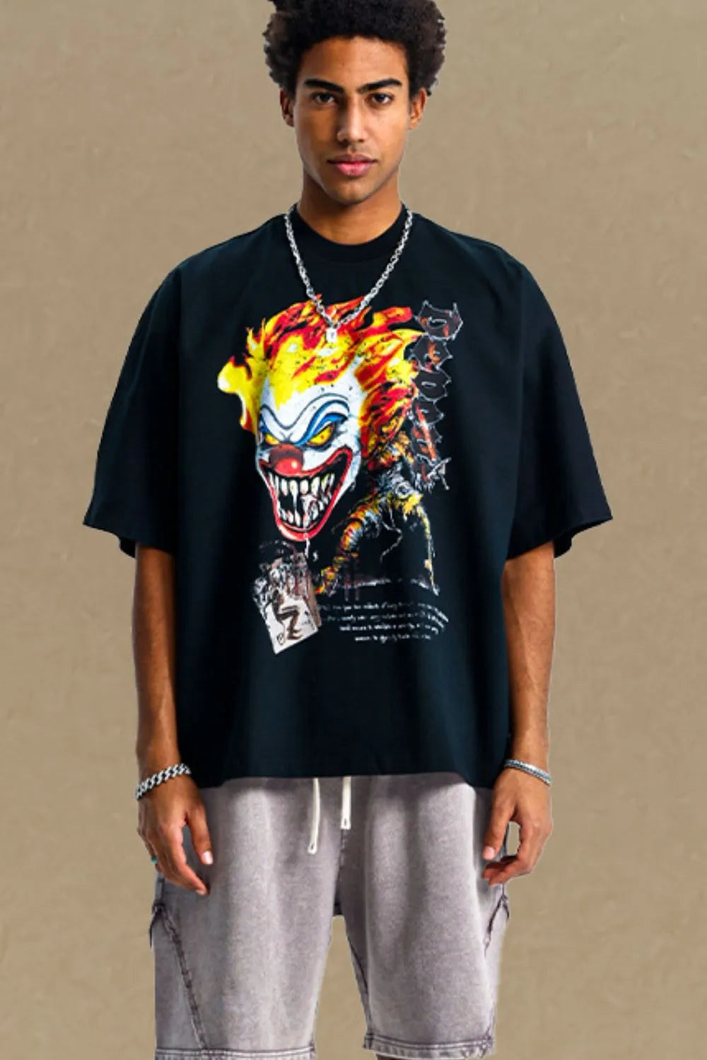 Black oversized t-shirt with a bold clown graphic print and short sleeves.