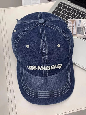 Dark blue denim baseball cap with white Los Angeles embroidery and contrast stitching.