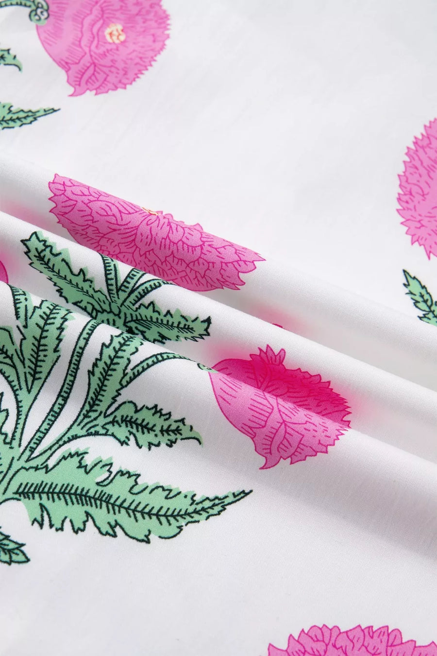 Vibrant floral mini dress with pink flowers and green leaves on white fabric.