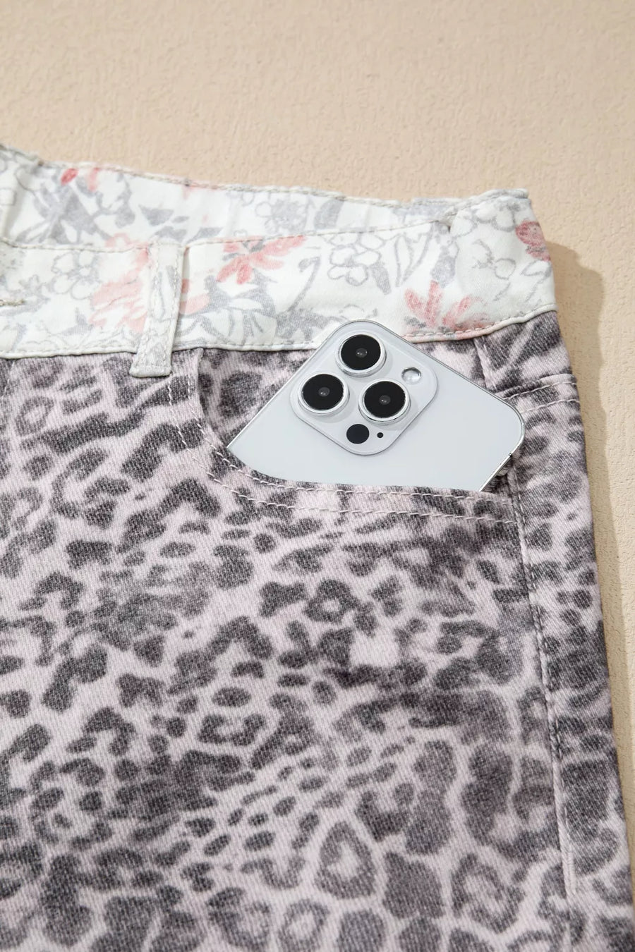 Wide-leg jeans with leopard print and floral waistband detail.