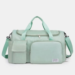 Light green canvas duffel bag with multiple utility pockets and adjustable strap.