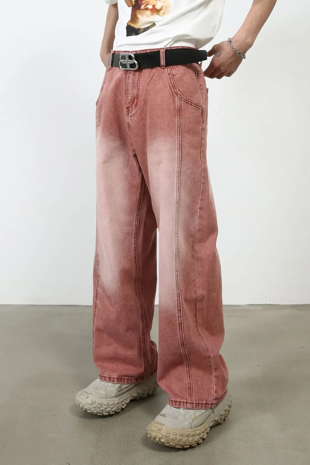 Relaxed fit coral denim jeans with a faded wash and wide leg, styled with a black belt.
