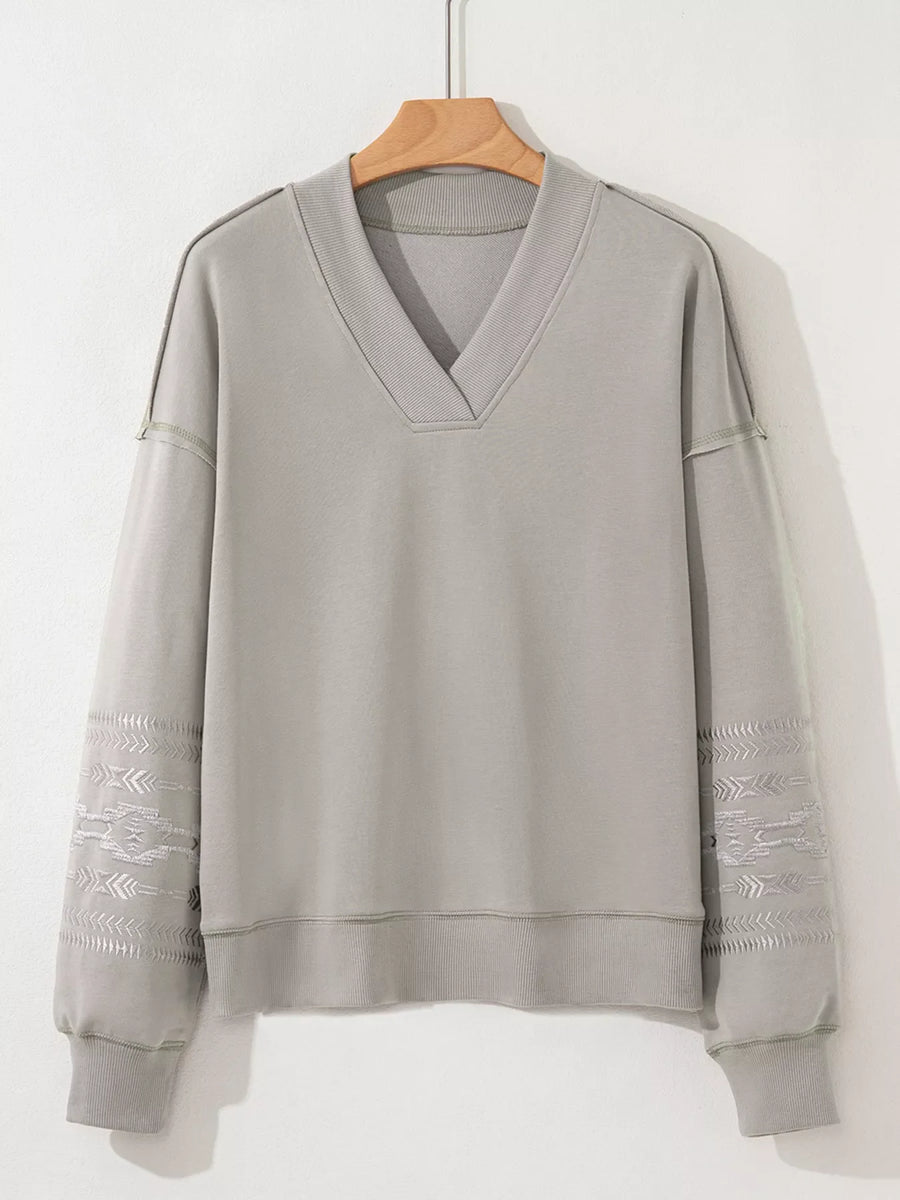 Gray V-neck sweatshirt with Aztec embroidered sleeves and comfortable fit