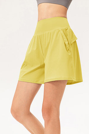 Yellow active shorts with layered pockets and a wide waistband.