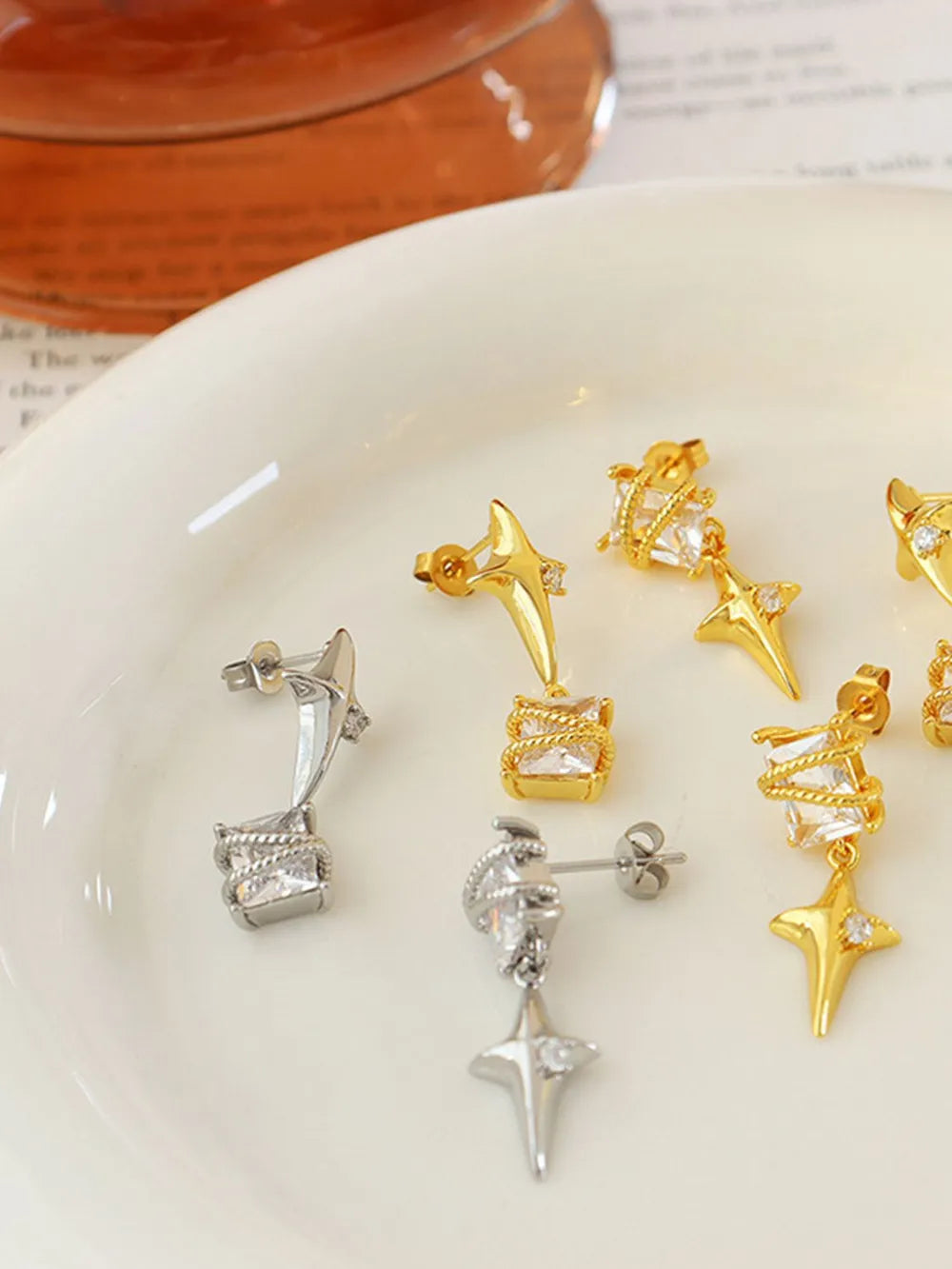 Celestial starburst crystal drop earrings in silver feature a square crystal and star charm.