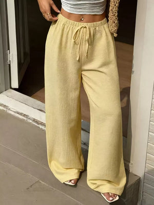 Yellow linen wide-leg pants with drawstring waist and textured fabric