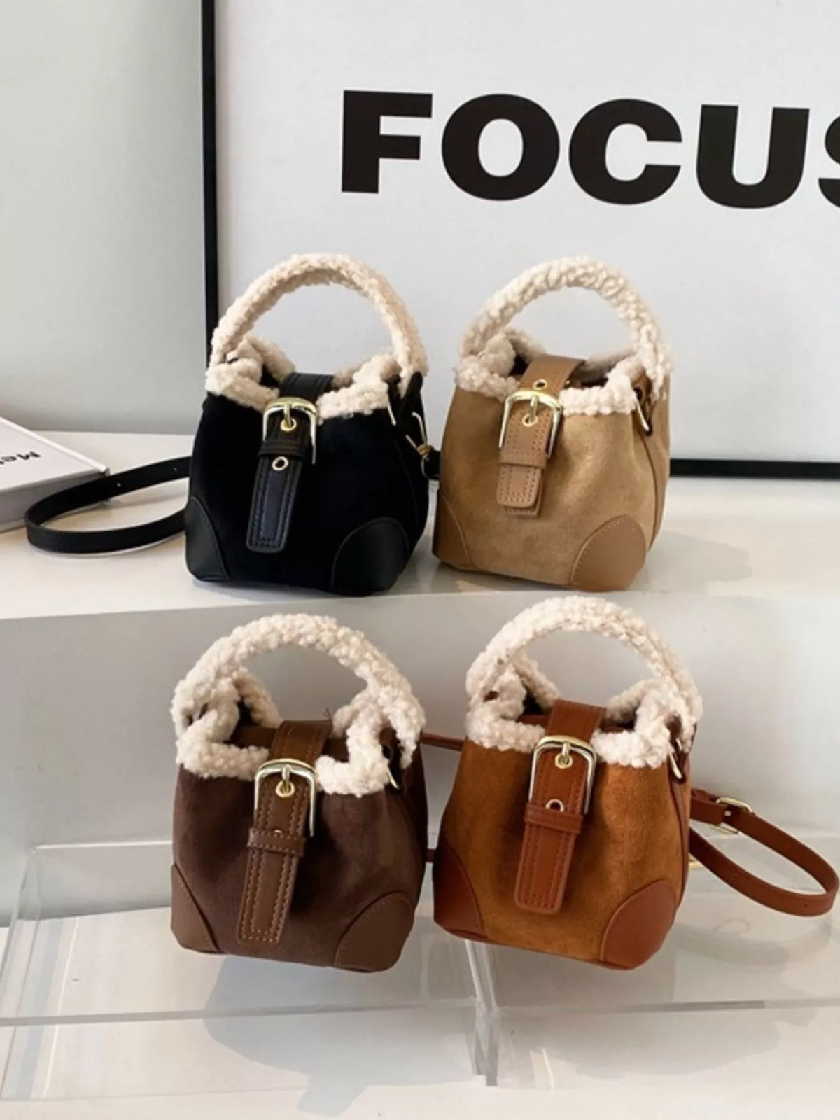 Fuzzy trim crossbody bucket bag in black, brown, khaki, and coffee brown with buckle detail.