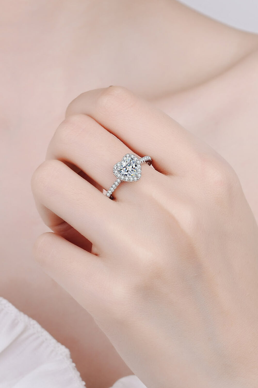 Silver ring with heart-cut diamond halo and brilliant band.