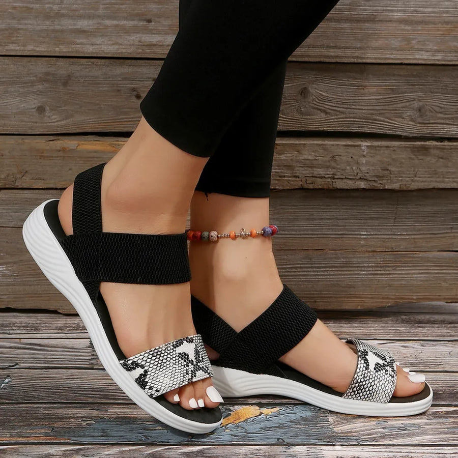 Geometric print elastic strap sandals with black straps and white soles.