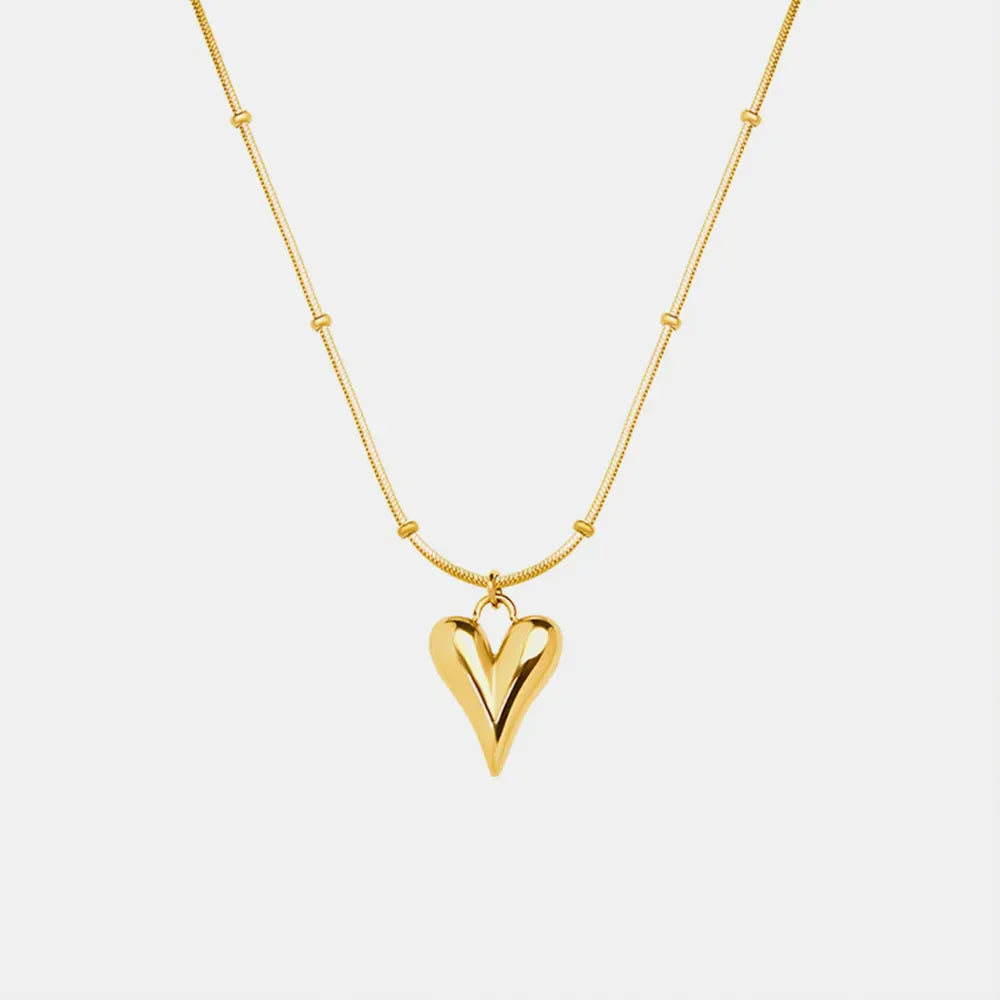 Gold necklace with beaded chain and sculpted heart pendant