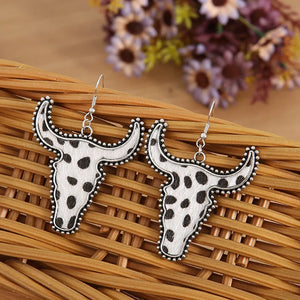 Cow print bull head drop earrings with silver trim.