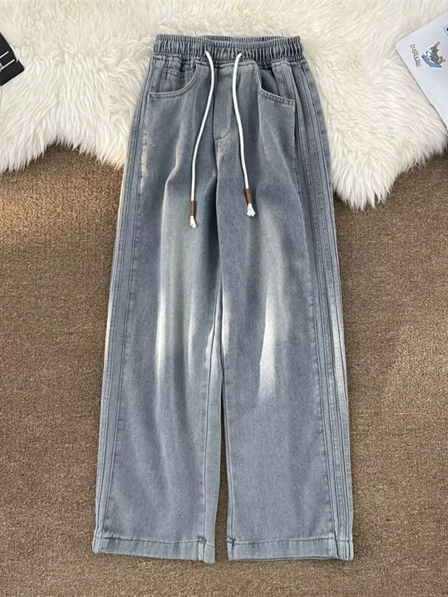 Men's light blue wide-leg jeans with drawstring waist and distressed details.