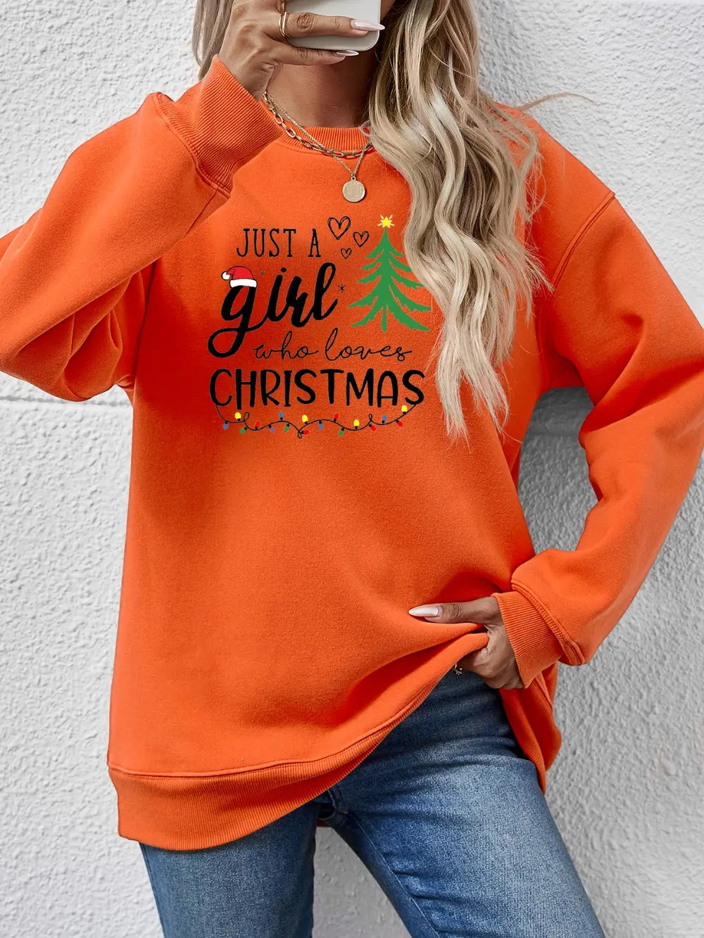 Orange crewneck sweatshirt with Christmas graphic and lights detail.