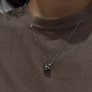 Celestial pearl and silver pendant necklace with delicate chain and small stones.