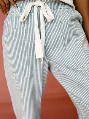 Mid rise drawstring jeans in light blue with white vertical stripes and pockets.