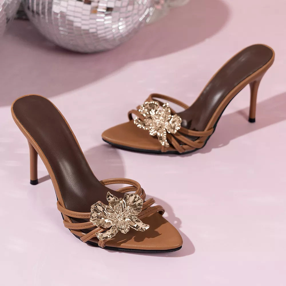 Brown high heel sandals with gold floral embellishments and thin straps.