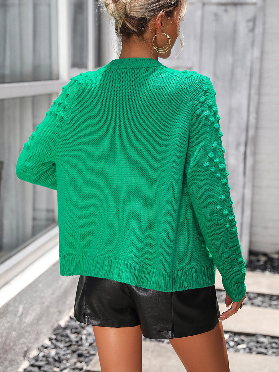 Green acrylic cardigan with textured sleeve details and ribbed hem.