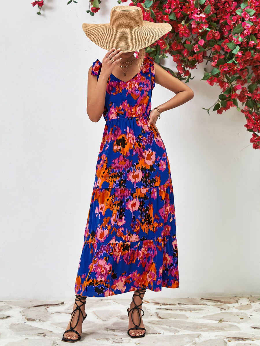 Maxi dress in dark blue with abstract print, tie straps, and tiered skirt.